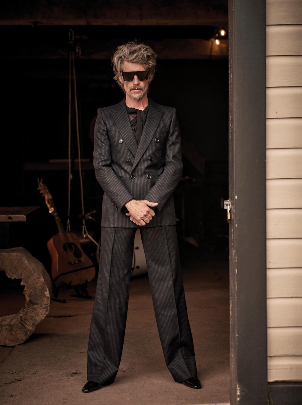 Jacket ($3,400), shirt ($2,290), trousers ($1,950), boots ($1,290), and sunglasses ($545), Saint Laurent by Anthony Vaccarello.