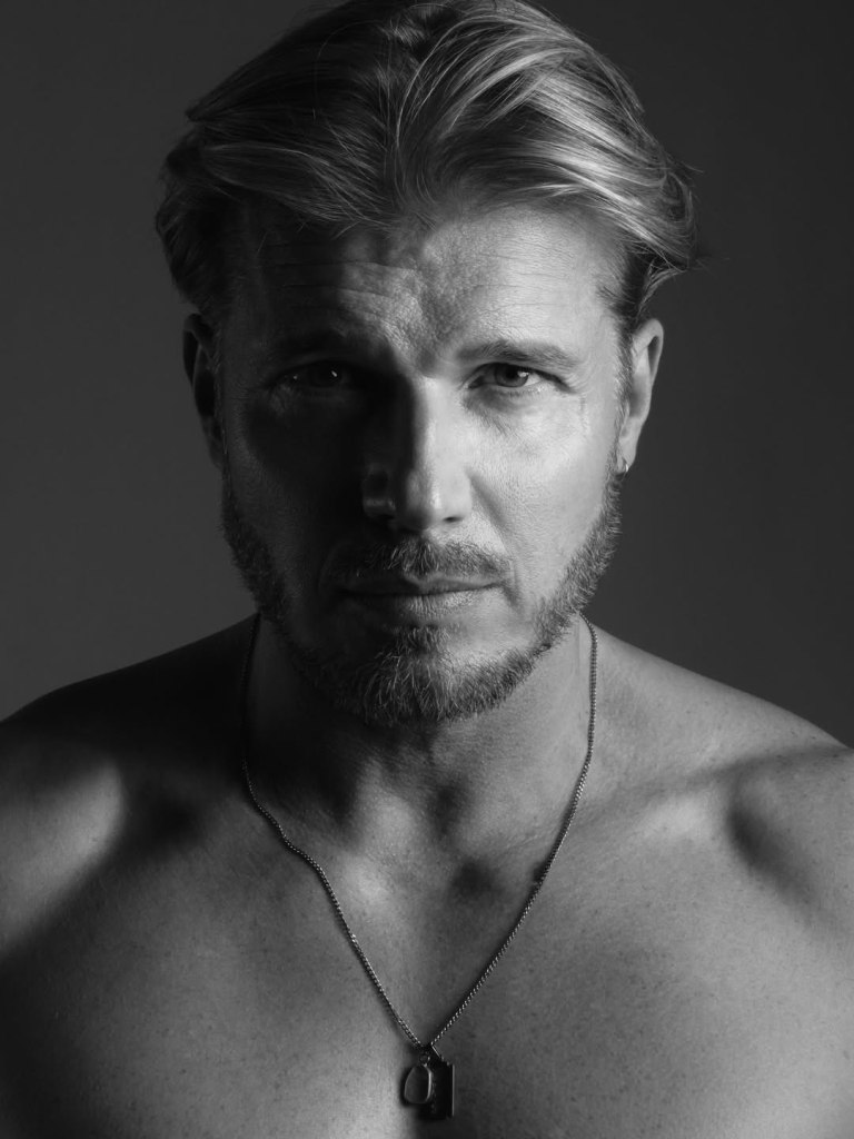 In Shadows Painted, Tomek Ciachorowski commands the frame with a presence shaped by time, discipline, and quiet confidence. 