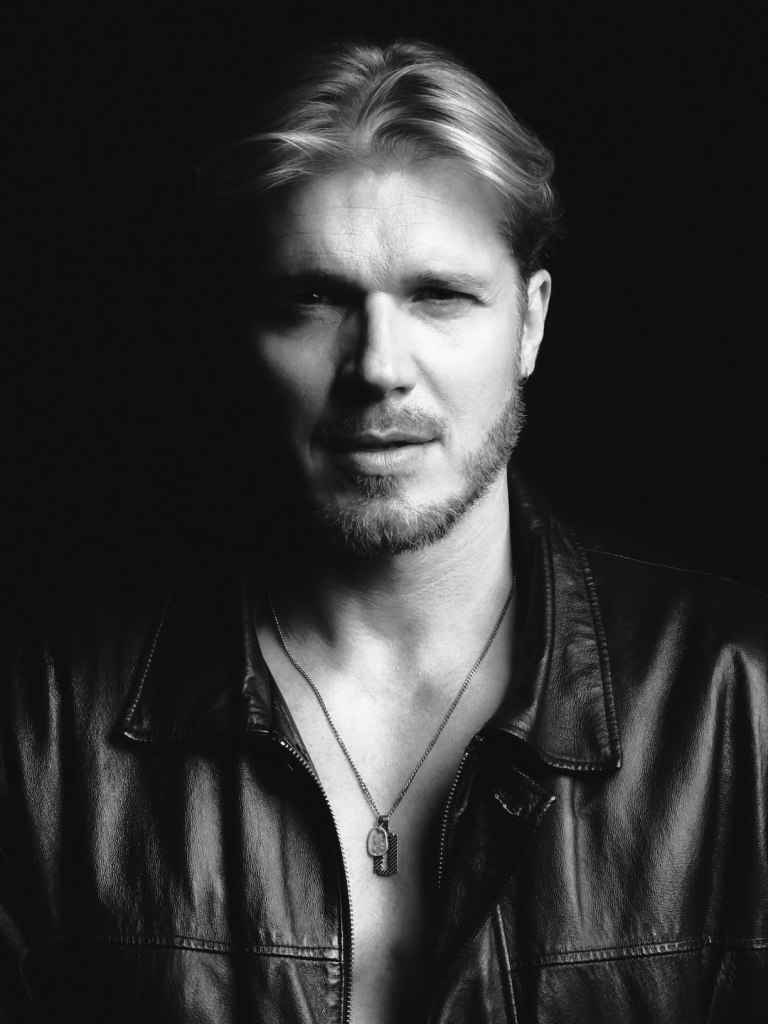 In Shadows Painted, Tomek Ciachorowski commands the frame with a presence shaped by time, discipline, and quiet confidence. 