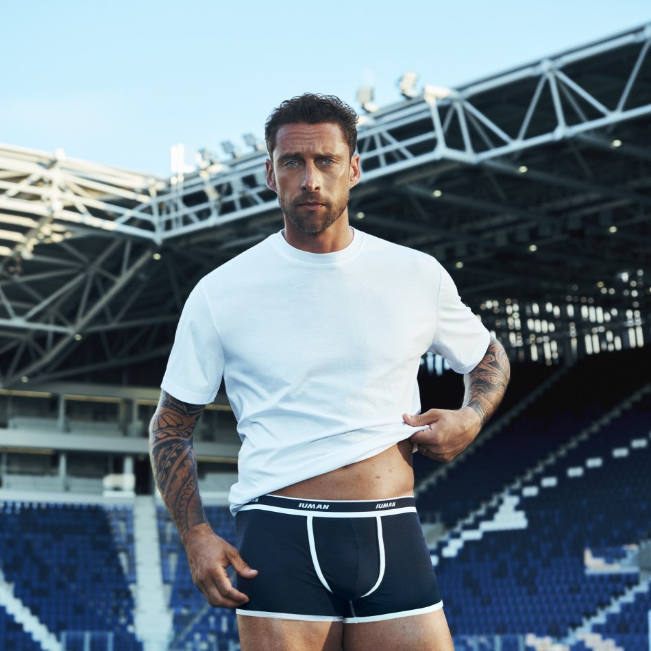 Claudio Marchisio modeling black boxer briefs and a white T-shirt at a football stadium.
