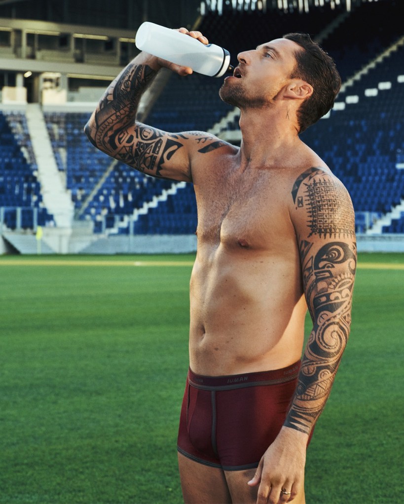 Italian football legend Claudio Marchisio drinking water on the pitch while wearing burgundy underwear.