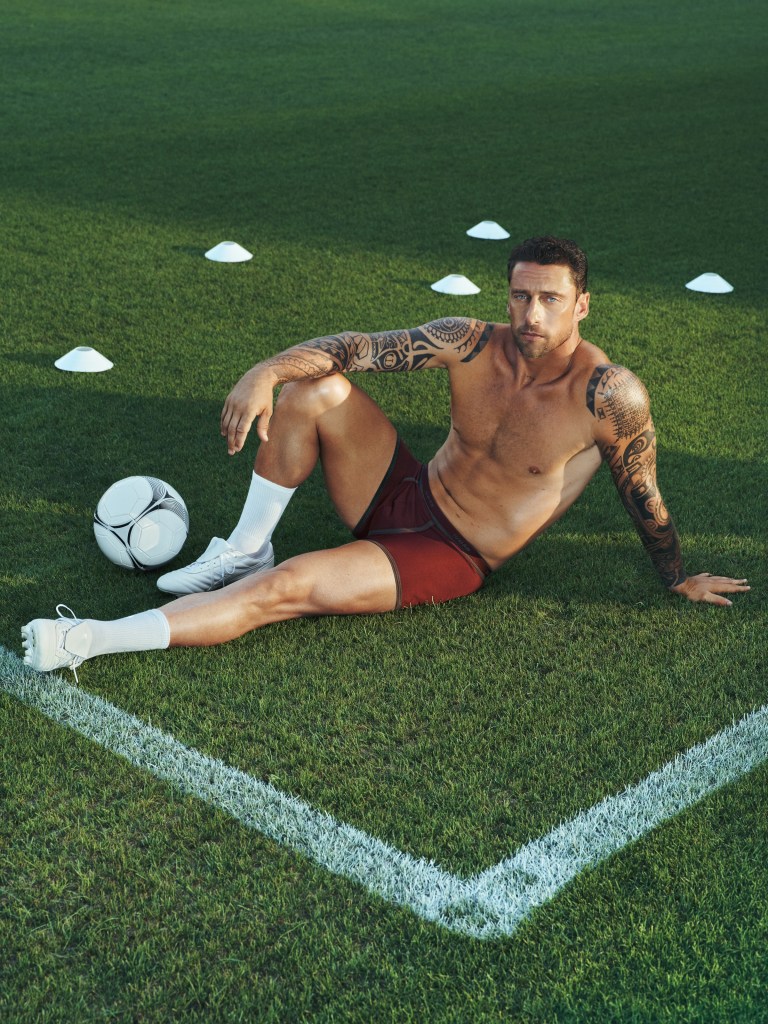 Former Juventus footballer Claudio Marchisio relaxing shirtless on a football pitch in burgundy IUMAN underwear.
